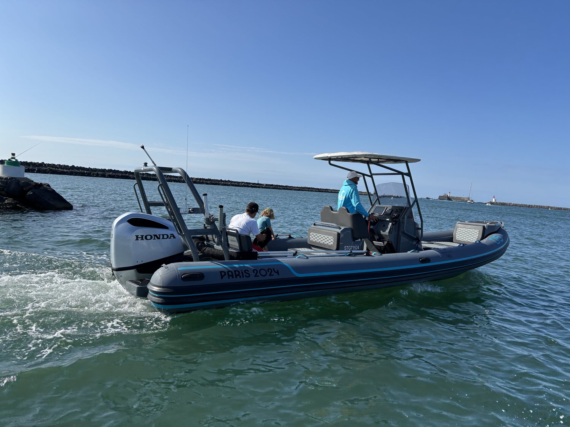 Le bateau de l’Institut Pelagia, semi-rigide gris à bandes bleues, quittant le port par mer calme